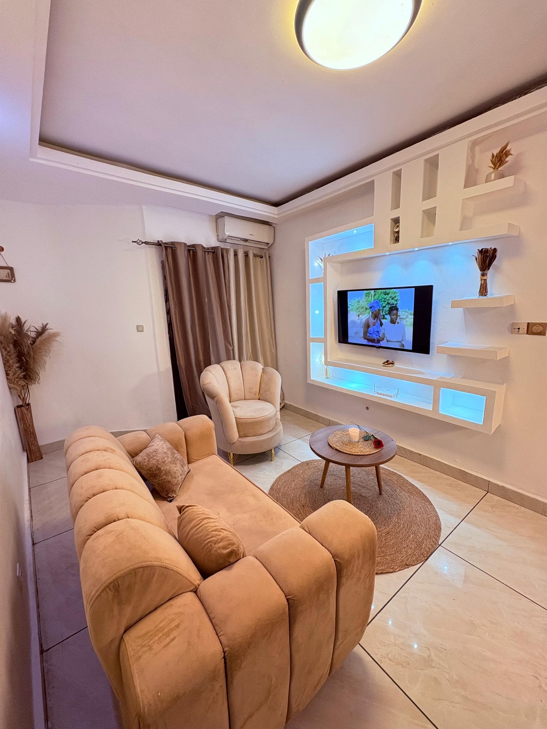Main living room of La Boeme with sofa, armchair, and wall-mounted TV