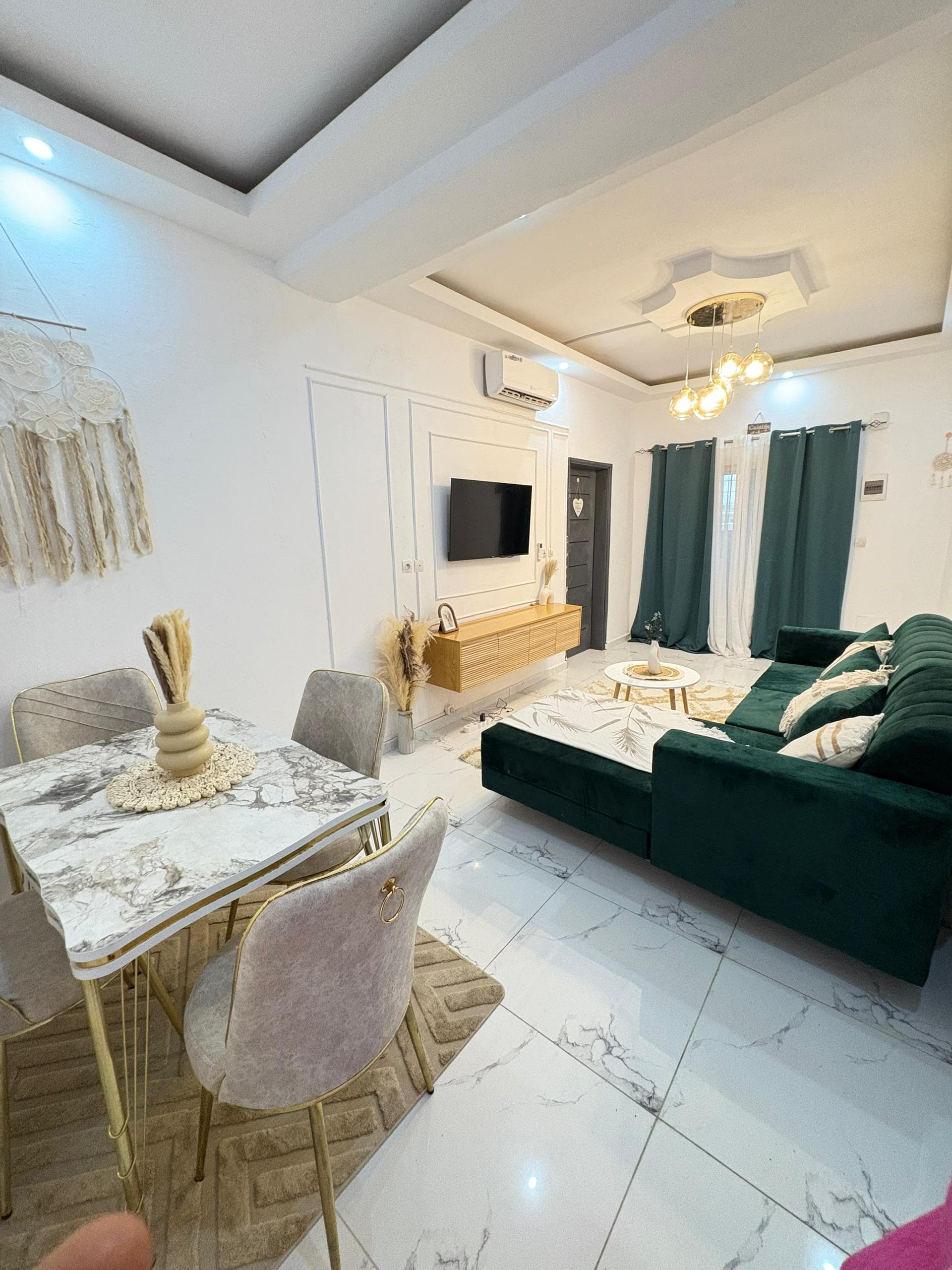 Main living room with dining nook, TV, and green sofa